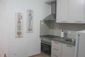 una cocina con armarios blancos y fregadero en Isaura Henriques, en Peniche
