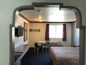 ein Hotelzimmer mit einem Bett und einem Tisch in der Unterkunft Starlight Inn, Valley Blvd - Downtown LA in Los Angeles