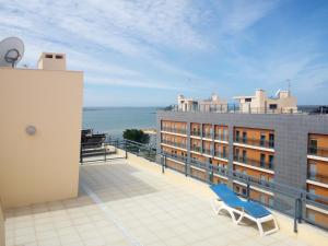 une chaise bleue sur le balcon d'un bâtiment dans l'établissement Fun & Sun Apartment, à Olhão