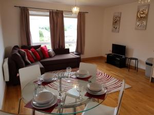 a living room with a glass table and chairs at Vetrelax Basildon City Center Apartment in Basildon