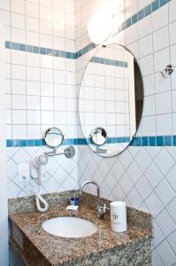 y baño con lavabo y espejo. en Atena Praia Hotel, en Boicucanga