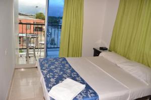 a bedroom with a bed and a balcony at Hotel Bahía Cadi in Puerto López