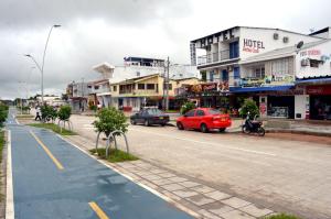 ulica miejska z samochodami jadącymi ulicą w obiekcie Hotel Bahía Cadi w mieście Puerto López