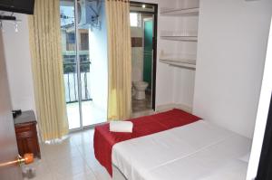 sypialnia z łóżkiem z czerwonym kocem w obiekcie Hotel Bahía Cadi w mieście Puerto López