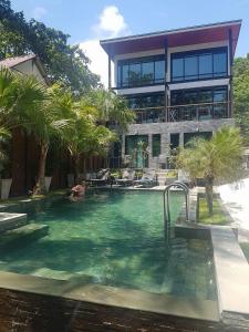a large swimming pool in front of a large building at 15 Palms Beach Resort in Ko Chang