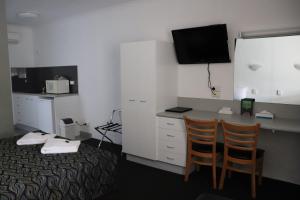 a hotel room with a bed and a television at Bundaberg Spanish Motor Inn in Bundaberg