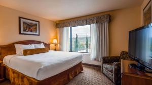 a hotel room with a bed and a large window at Best Western El Grande Inn in Clearlake