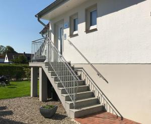 ティメンドルファー・シュトラントにあるFerienhaus Eddaの白い家に続く階段