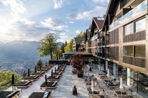 una fila di panchine su un balcone di un edificio di Miramonti Boutique Hotel a Avelengo