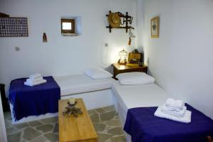 a room with two beds and a table in it at Nostos Residence - Apartment Terra in Tselendáta