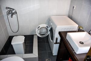 y baño con lavabo y lavadora. en Nostos Residence - Apartment Terra, en Tselendáta