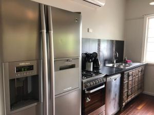 a kitchen with a stainless steel refrigerator and a stove at Five 3 Five in Hervey Bay