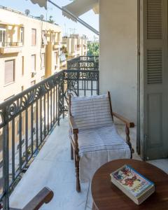 einen Balkon mit einem Stuhl und einem Tisch in der Unterkunft Plaka Vintage in Athen