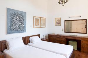 2 Betten in einem Zimmer mit einem TV an der Wand in der Unterkunft Plaka Vintage in Athen