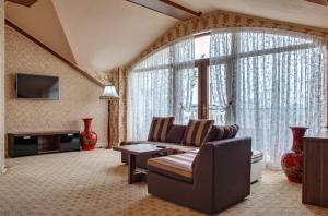 a living room with a couch and a large window at City Line Boutique Hotel in Tashkent
