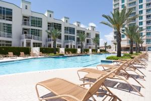 a swimming pool with lounge chairs and a resort at Sapphire in South Padre Island