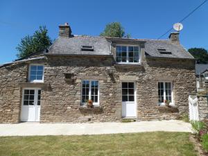 an old stone house with white doors and windows at Gite Ker Maria Gite Ker Louis Piscine in Saint-Gravé