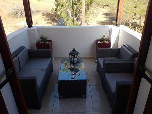a porch with couches and a table on a balcony at Santorini Family Apartments in Kamari