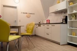 a kitchen with yellow chairs and a table at Altstadt-Apartment in Freiberg