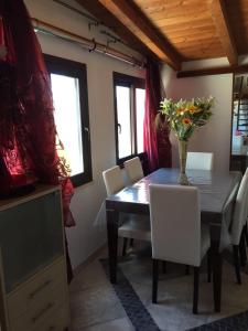 a dining room table with chairs and a vase of flowers on it at Bla Bla House Alghero-Olmedo in Olmedo