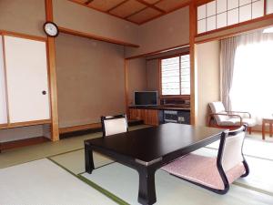 a living room with a black table and chairs at Itoen Hotel Toi in Izu