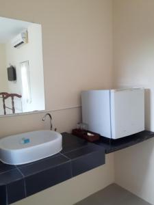 La salle de bains est pourvue d'un lavabo et d'un miroir sur un comptoir. dans l'établissement Classic home, à Bang Tao Beach