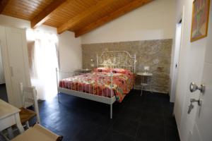sypialnia z łóżkiem i kamienną ścianą w obiekcie Al Giardino di Anna w mieście Fondi