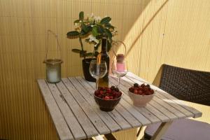 a wooden table with two bowls of cherries and a wine glass at House & The City - Apartments in Rome in Rome