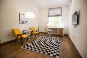 een woonkamer met een tafel en stoelen en een geruit tapijt bij Art Apartment in Tasjkent