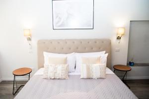 sypialnia z dużym łóżkiem z białymi poduszkami w obiekcie SuityRHome RioneMonti16 w Rzymie