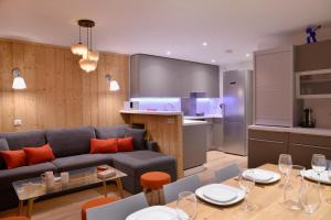 Belle Plagne Premium في بيل بلاني: غرفة معيشة ومطبخ مع أريكة وطاولة