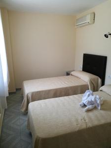 Habitación de hotel con 3 camas y toallas. en Hotel l'Albera en La Jonquera