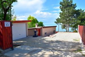 a house with a garage and a fence at Kenese Panoráma Apartman in Balatonkenese