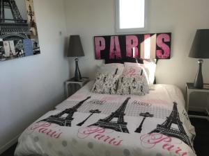 um quarto com uma cama com um sinal de Paris em Villa d'escane em Escanecrabe