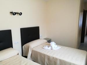Habitación con 2 camas y toallas. en Hotel l'Albera en La Jonquera