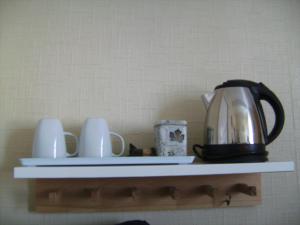 a shelf with a tea kettle and mugs on it at Dolphin Guesthouse in Scarborough