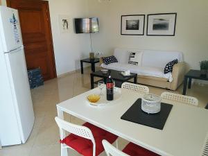 a kitchen and living room with a white table and chairs at Themis Apartments in Sami