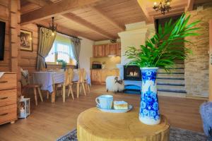 sala de estar con mesa y jarrón con planta en Folk Resort Domki i Apartamenty, en Murzasichle