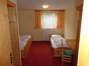 ein kleines Zimmer mit 2 Betten und einem Fenster in der Unterkunft Holiday-Appartements in Flachau