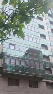 a tall glass building with a lot of windows at San Lorenzo House in Gijón
