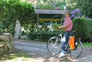 a man riding a bike in front of a sign at Immenhagen Ferienwohnungen in Malente
