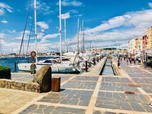 a marina with boats and people walking on a pier at 3 plan des boucaniers in Cap d'Agde