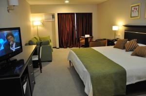 a hotel room with a bed and a flat screen tv at Condado Hotel Casino Goya in Goya