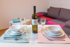 una mesa con una botella de vino, platos y copas en Fiorelin en Pula