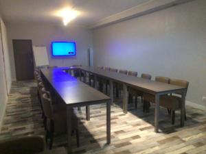 une salle de conférence avec une grande table et des chaises dans l'établissement Hôtel de La Beauronne, à Chancelade