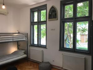 a room with windows and a bunk bed in it at Passpartout Hostel in Timişoara