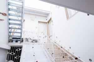 eine Treppe in einem Zimmer mit weißen Wänden und Fenstern in der Unterkunft Casa Vacanze Capitano in Porto Cesareo