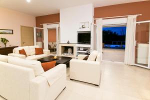 sala de estar con muebles blancos y chimenea en Corfu Erimitis, en Ágios Stéfanos