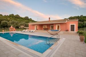 a villa with a swimming pool and a house at Corfu Erimitis in Ágios Stéfanos