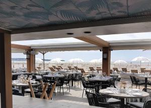 a restaurant with tables and chairs on the beach at 7 Croisette in Cannes